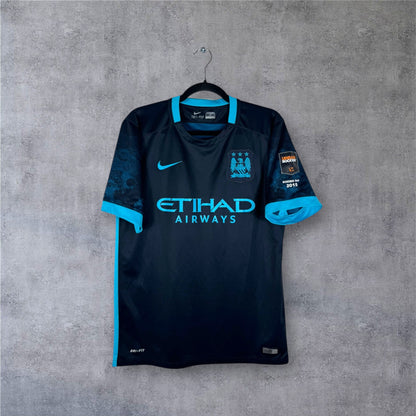 Vue de face du maillot Manchester City Extérieur 2015/16 bleu foncé avec manches graphiques.