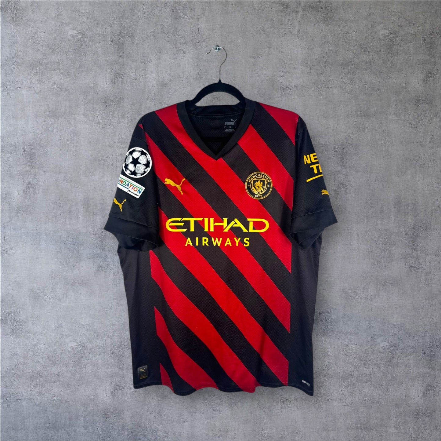 Vue de face du maillot Manchester City Extérieur 2023 à rayures diagonales.