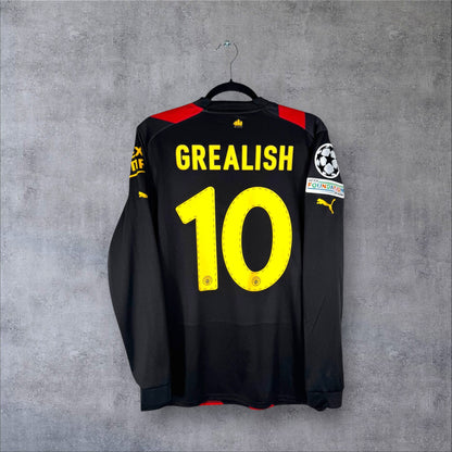 Dos du maillot Manchester City Extérieur 2023 noir et rouge avec flocage jaune GREALISH 10 et patchs Ligue des Champions.