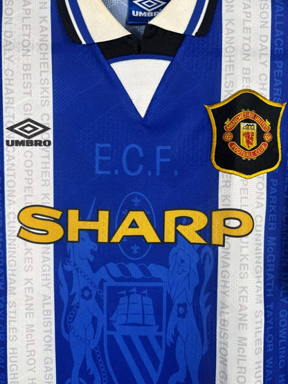 Détail du sponsor Sharp, du col polo et des armoiries de Manchester sur le maillot United 1994-1995 third