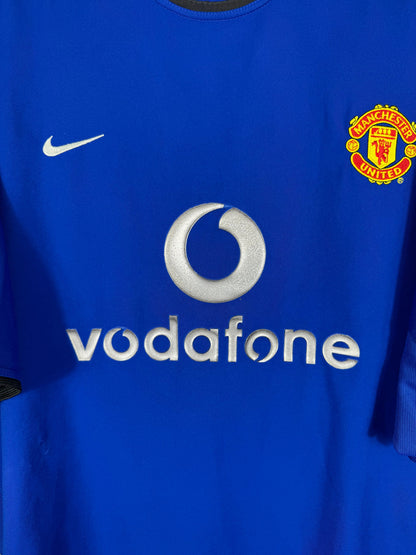 Détail écusson Manchester United, swoosh Nike et sponsor Vodafone sur maillot third 2002-2003