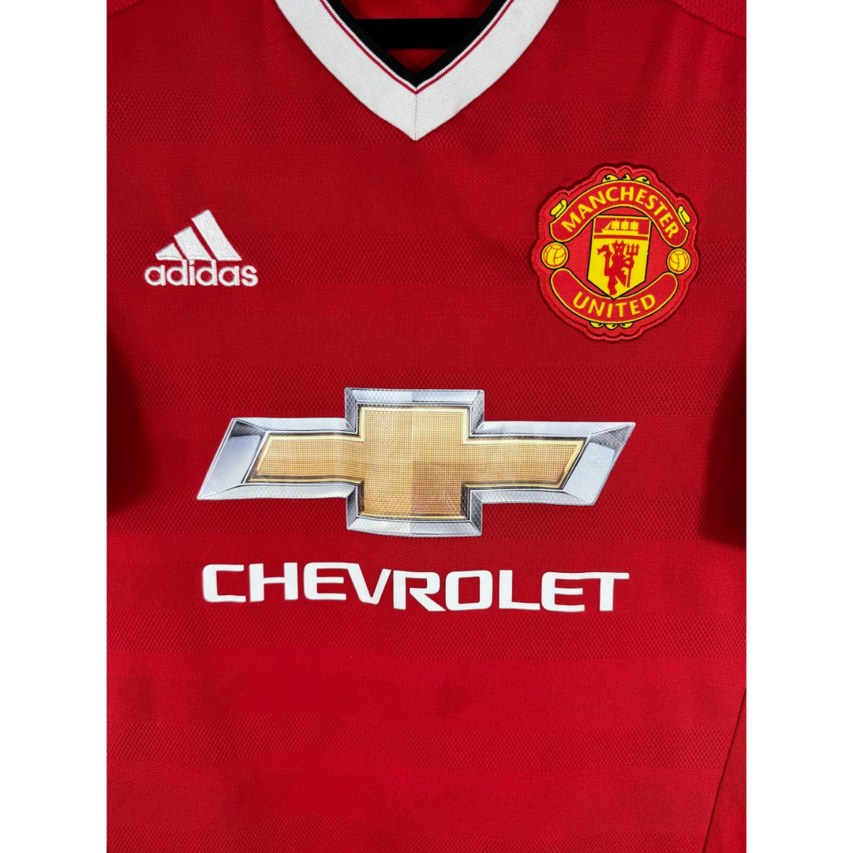Détail de l'écusson de Manchester United et du logo Adidas