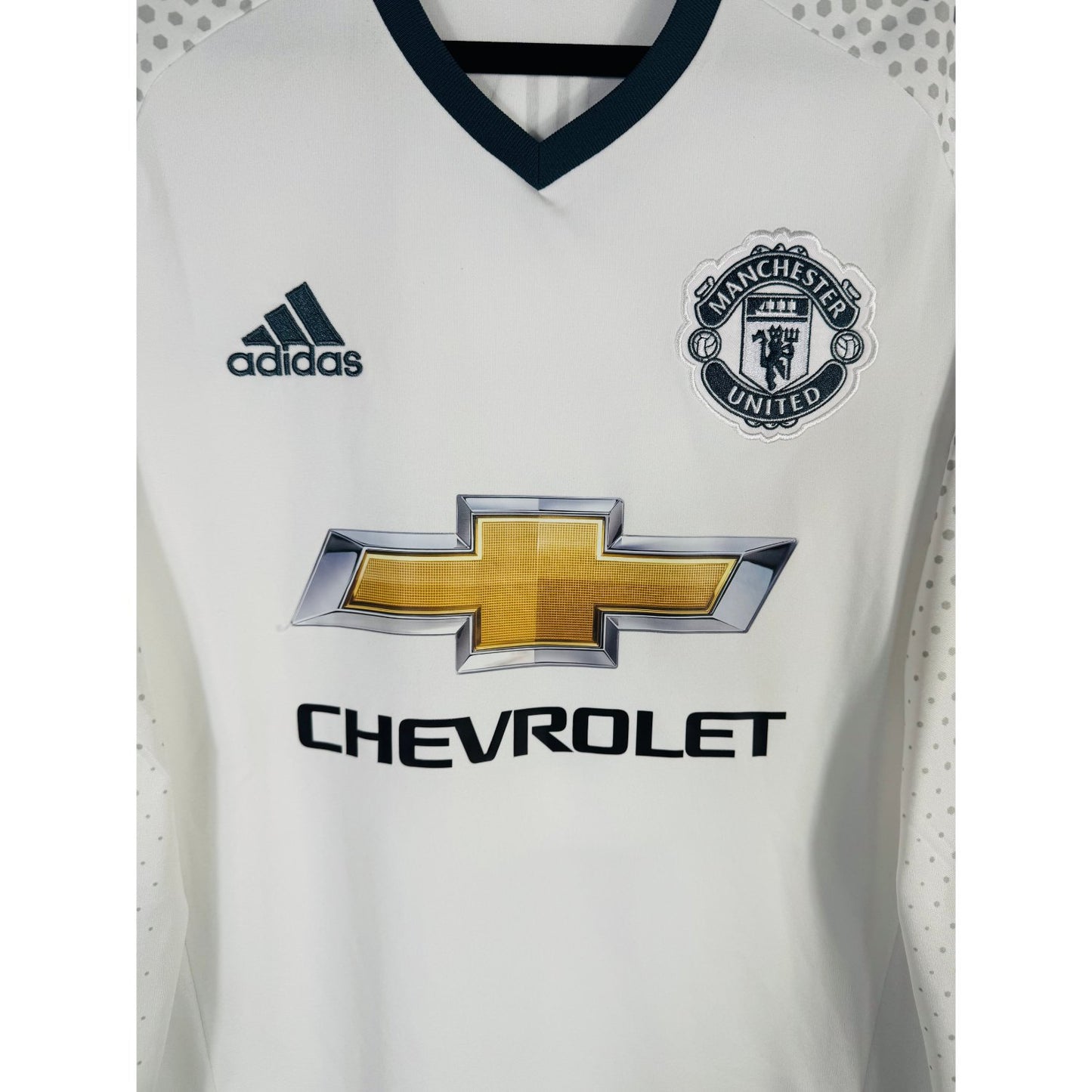 Détail de l'écusson de Manchester United et du logo Adidas