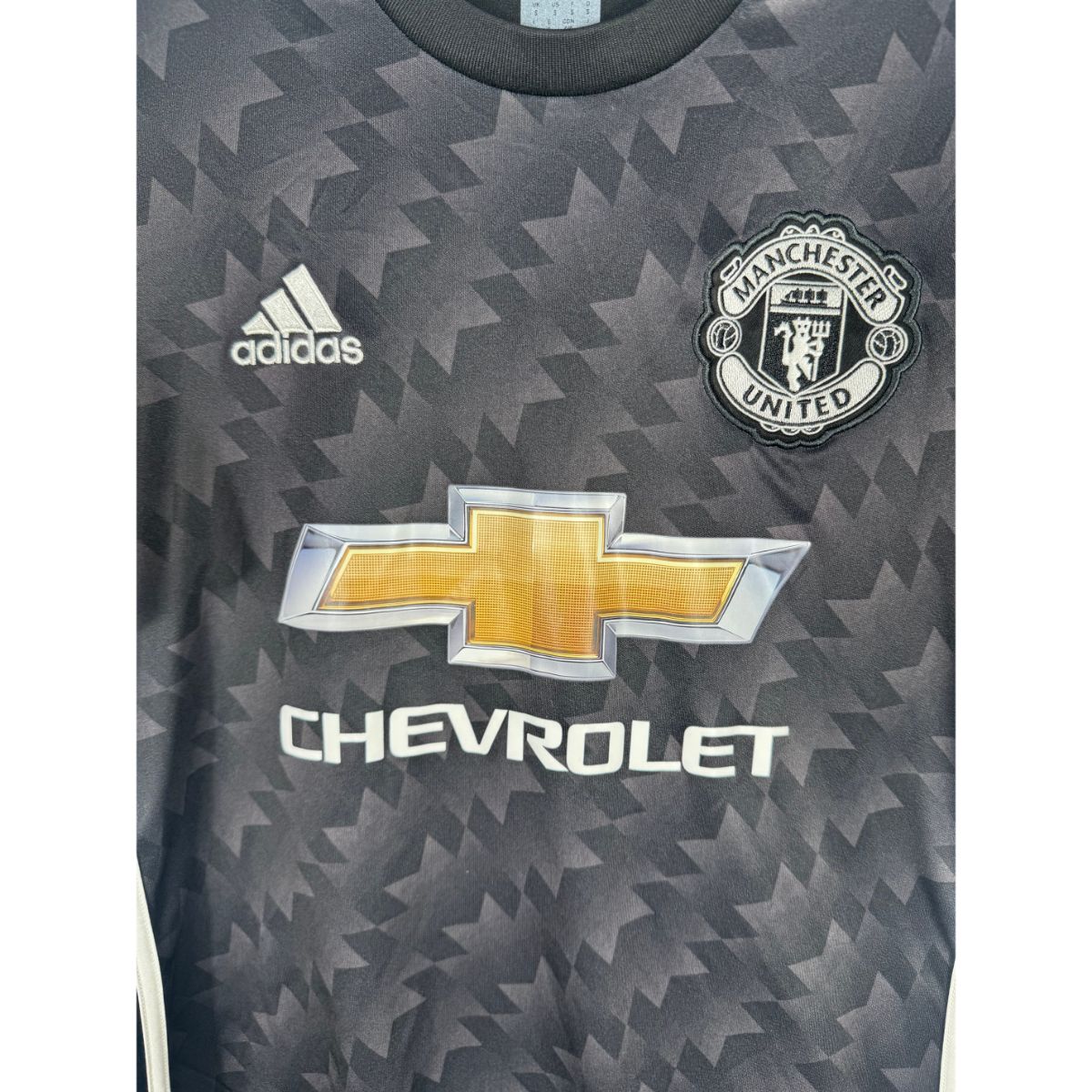 Détail de l'écusson de Manchester United et du logo Adidas
