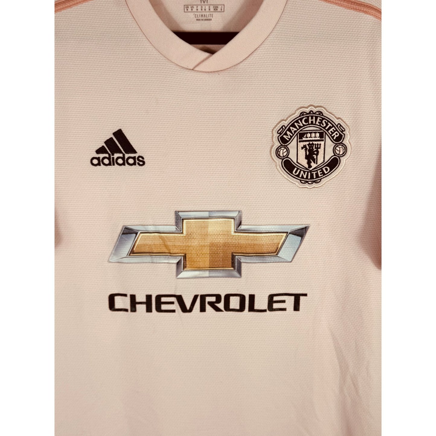 Détail de l'écusson de Manchester United et du logo Adidas
