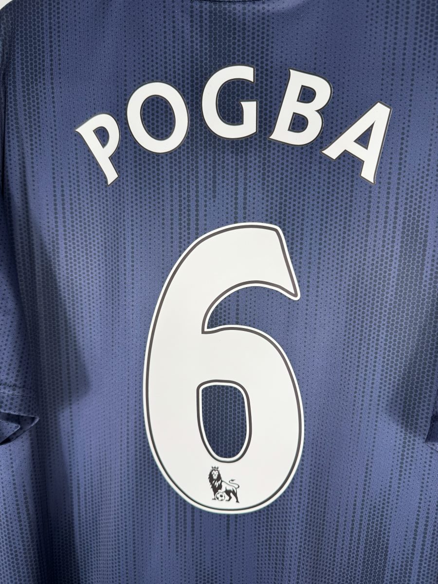 Gros plan du flocage Pogba N°6 du maillot Manchester United third 2018-2019 avec le lion Premier League sous le chiffre