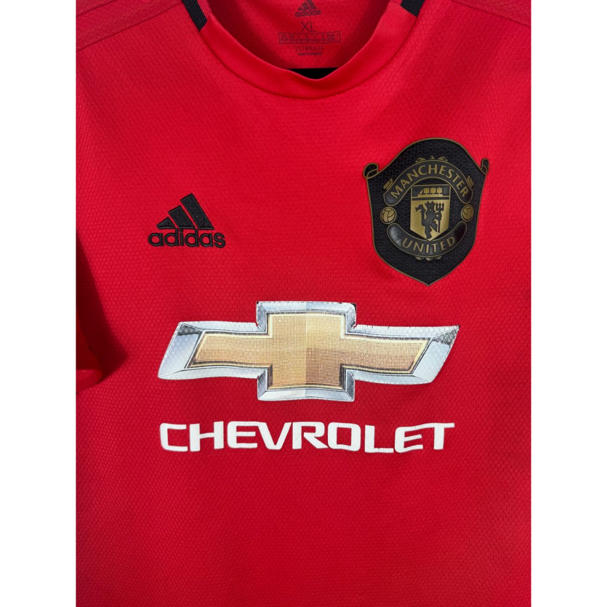 Détail de l'écusson spécial "Treble 99" de Manchester United et du logo Adidas