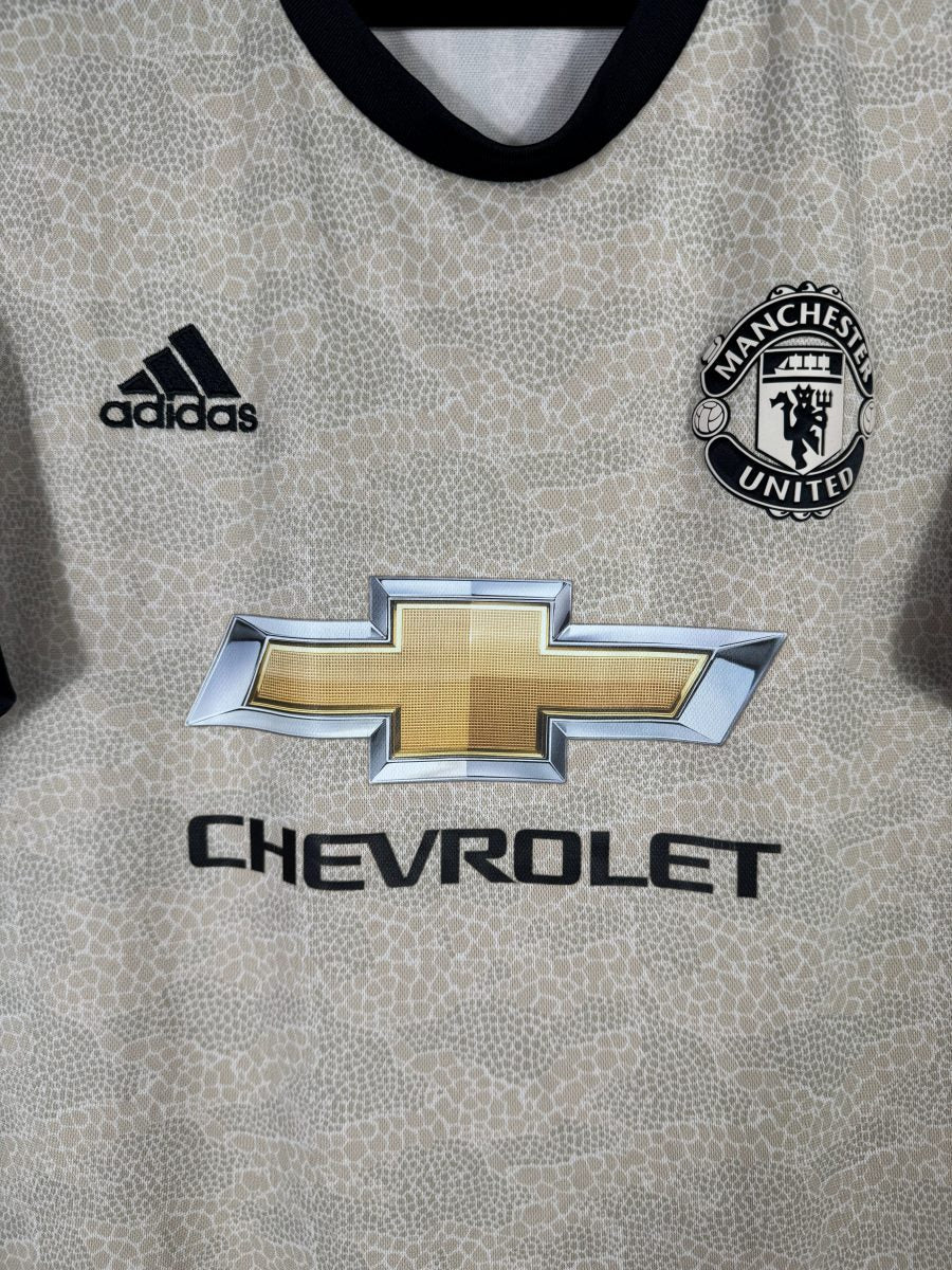 Détail du blason Manchester United, du logo adidas et du sponsor Chevrolet sur le maillot extérieur 2019-2020