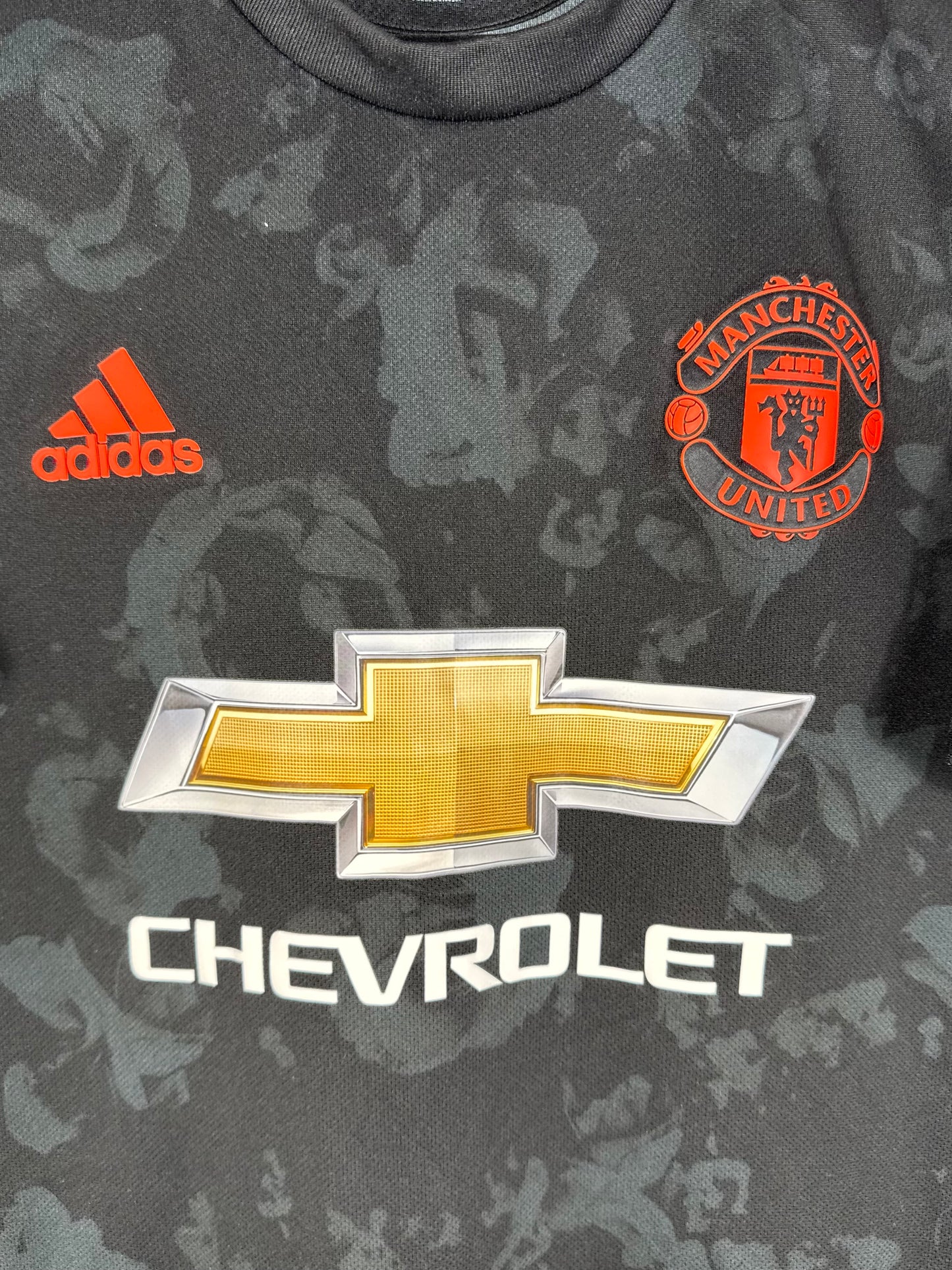 Détail de l'écusson de Manchester United et du logo Adidas