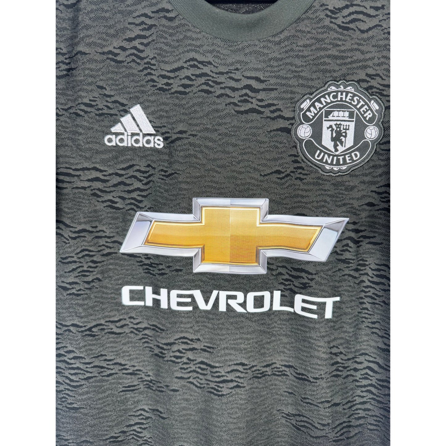 Détail de l'écusson de Manchester United et du logo Adidas