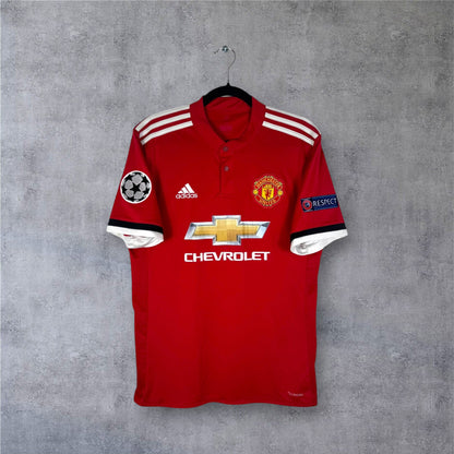 Vue de face du maillot Manchester United 2017/18 rouge avec col boutonné et sponsor Chevrolet.