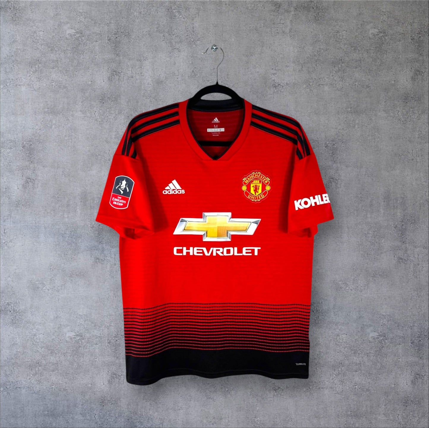 Vue de face du maillot Manchester United Domicile 2018/19 rouge avec dégradé noir vers le bas et sponsor Chevrolet.