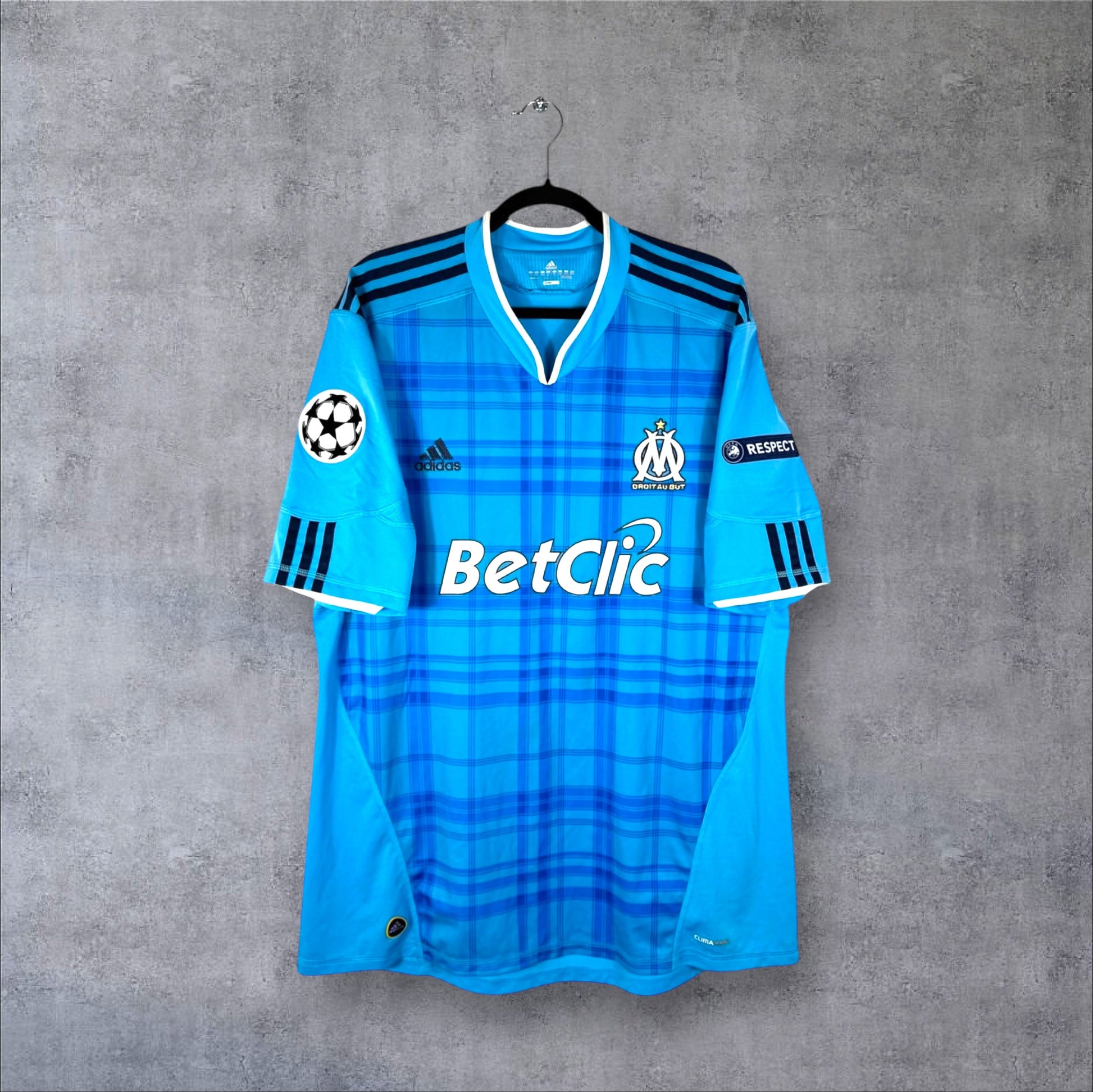 Vue de face du maillot OM 2010-2011 extérieur avec motif à carreaux bleus et sponsor BetClic.