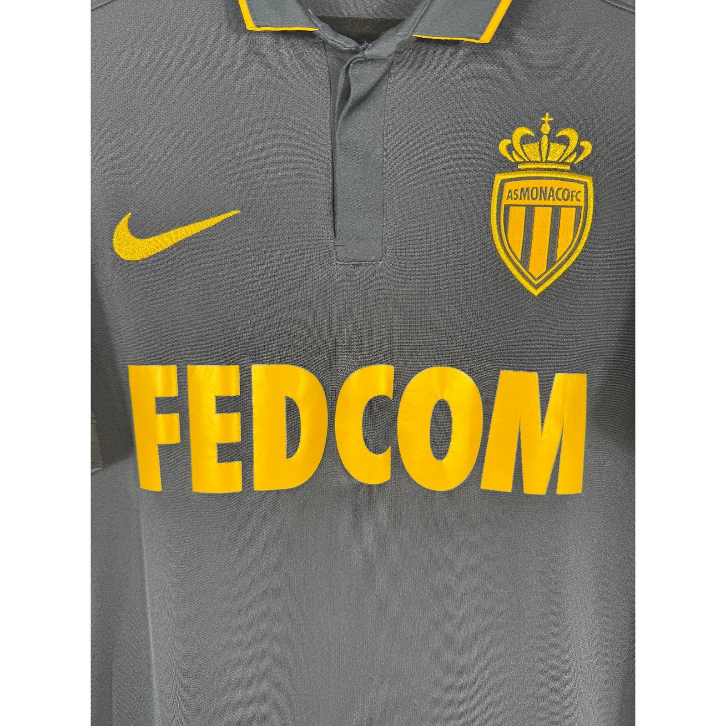 Détail écusson AS Monaco doré, swoosh Nike et sponsor Fedcom sur maillot third 2016-2017