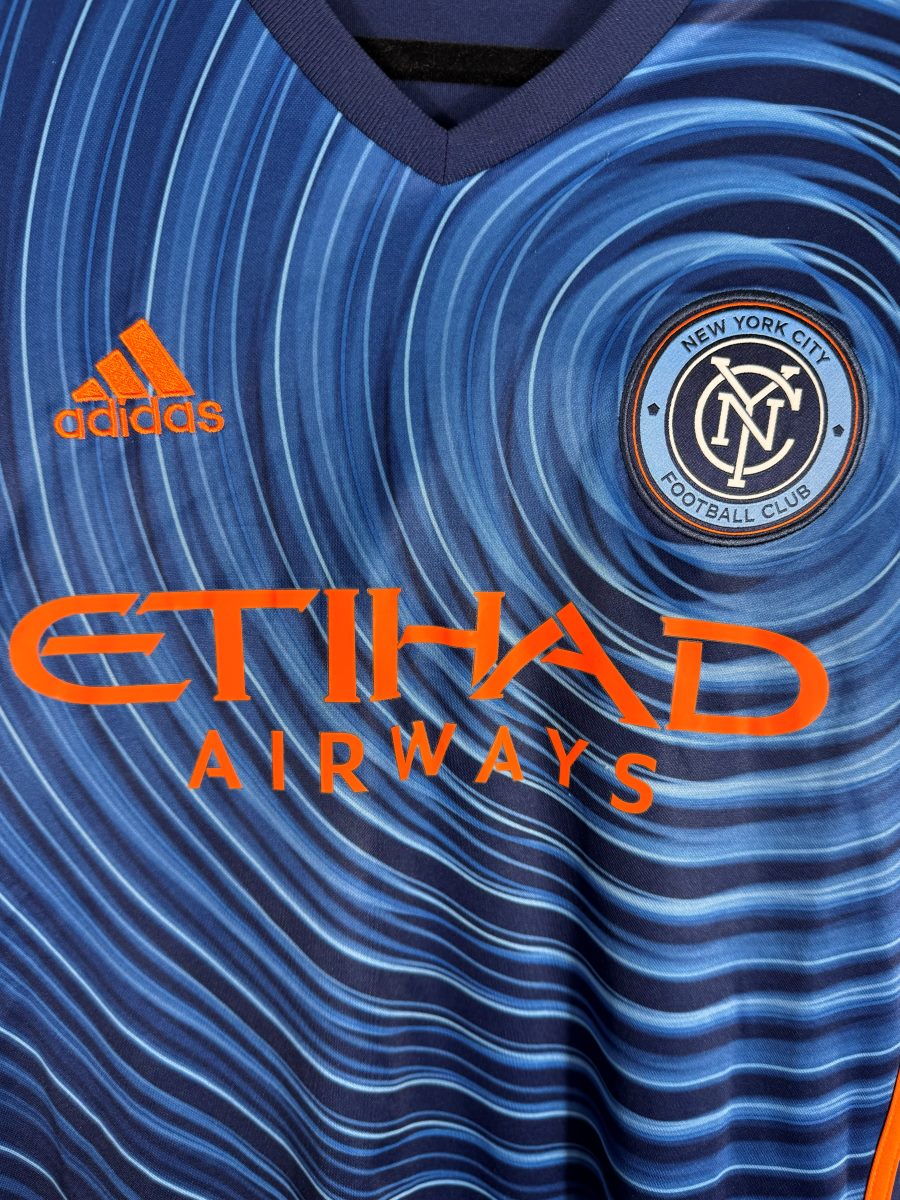 Détail de l'écusson circulaire New York City FC et du sponsor Etihad Airways sur le maillot extérieur 2016-2017