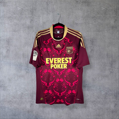 Face du maillot OL 2010-2011 extérieur adidas, sponsor Everest Poker et motif arabesques roses