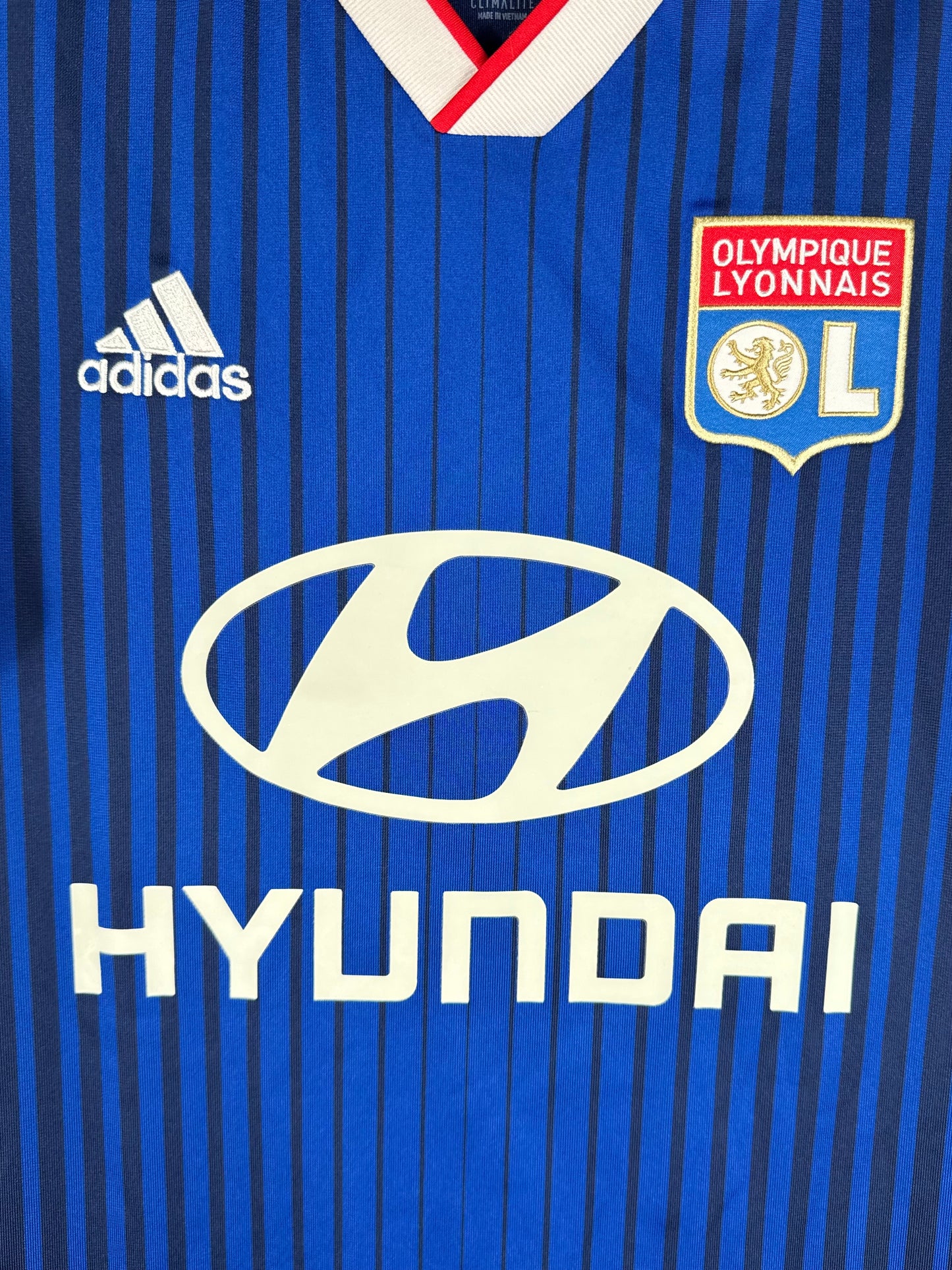 Détail de l'écusson de l'OL et du logo brodé Adidas