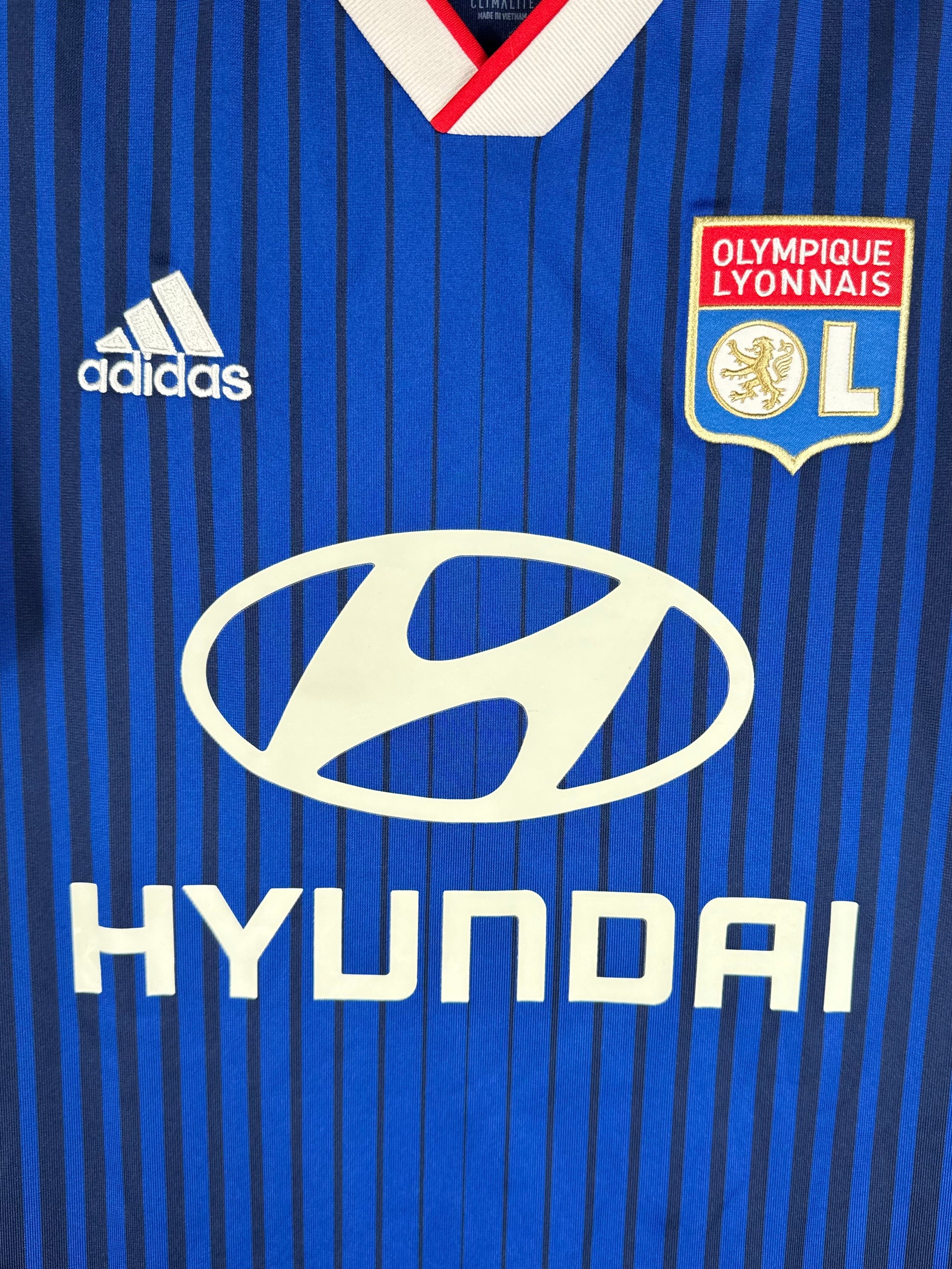 Détail de l'écusson de l'OL et du logo brodé Adidas