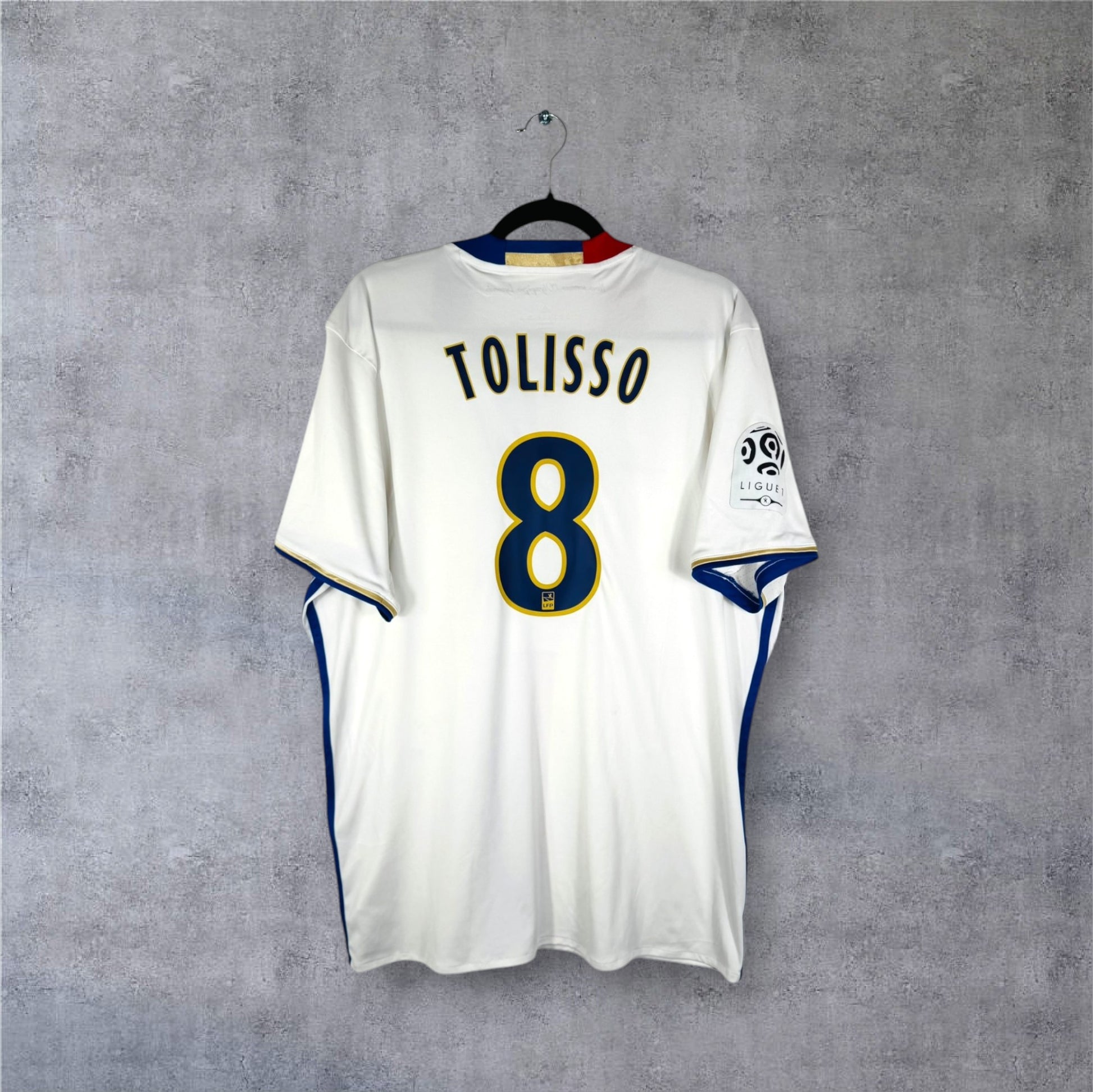 Dos du maillot de l'Olympique Lyonnais 2017 blanc avec flocage bleu TOLISSO 8 en taille XL.
