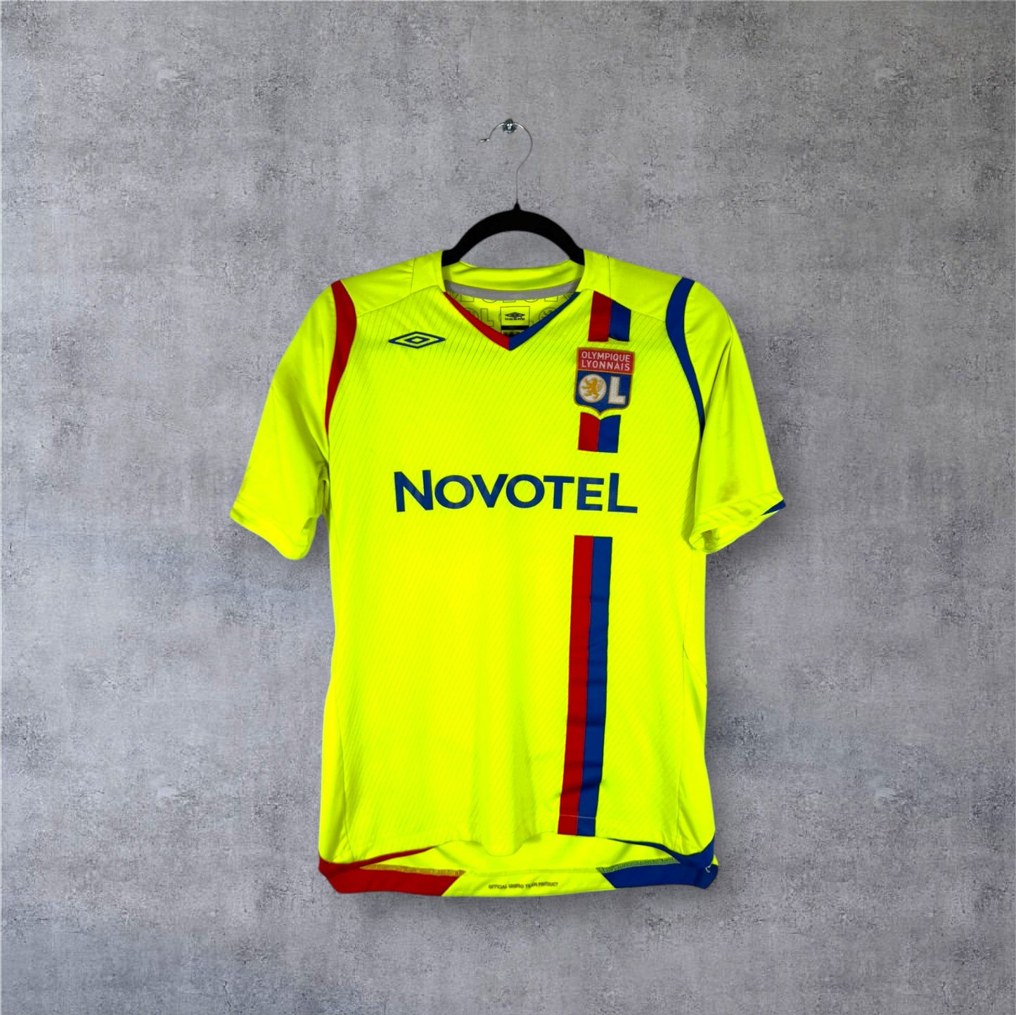 Vue de face du maillot OL 2008/09 Third jaune fluo et bleu marine avec sponsor Novotel.