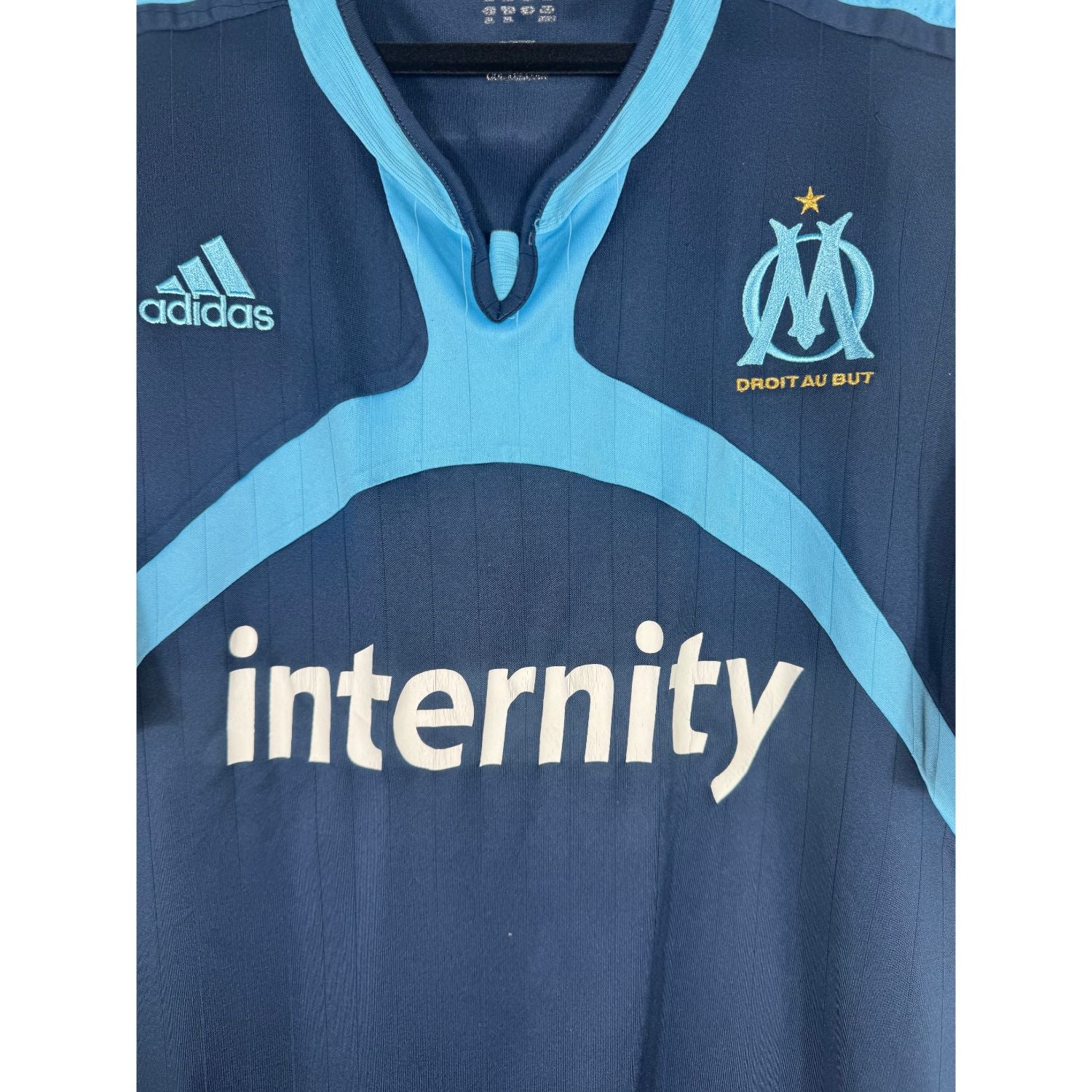 Détail de l'écusson de l'OM et du logo Adidas