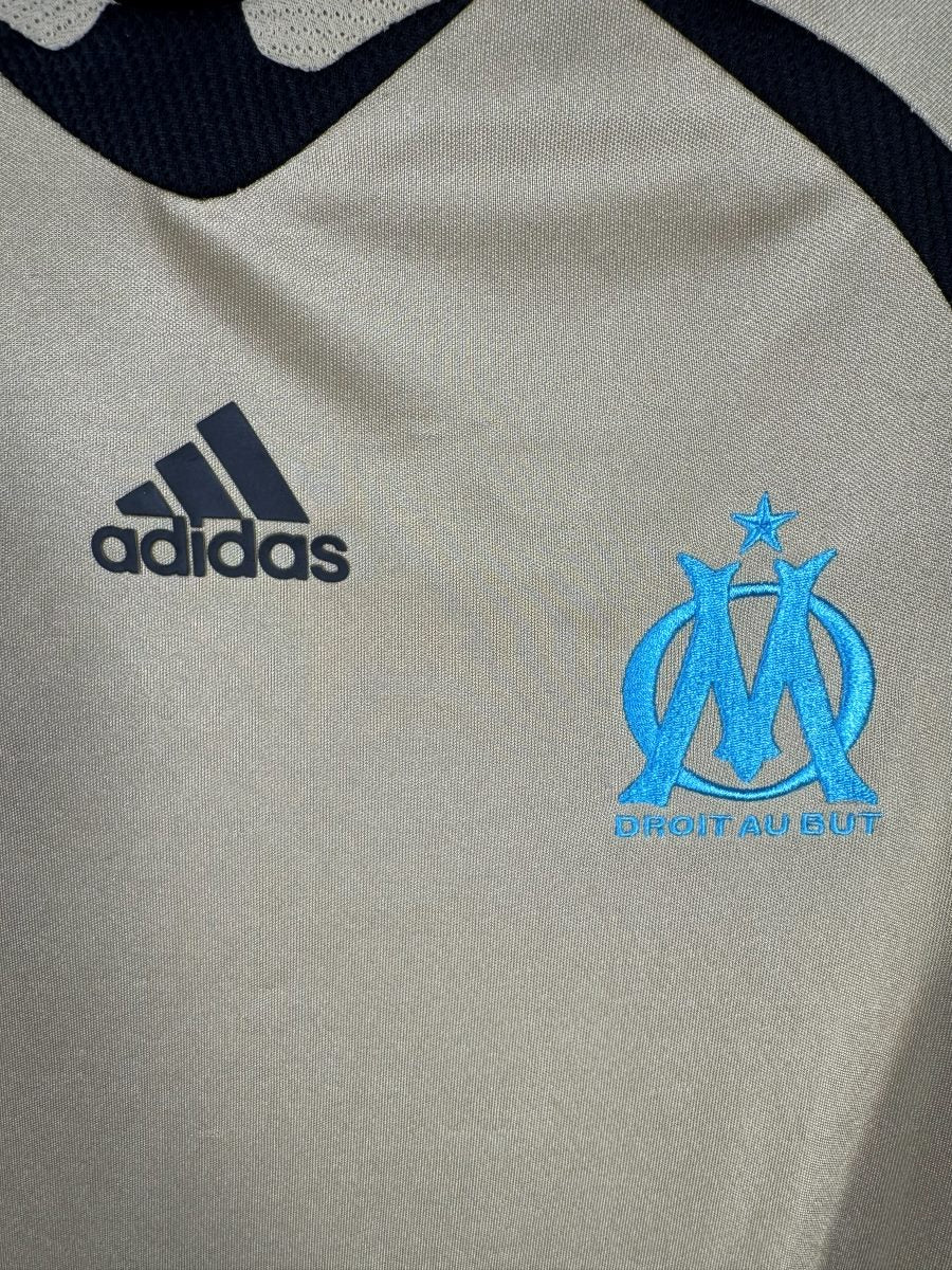 Écusson OM brodé bleu ciel et logo adidas, maillot third or 2008-2009 Taiwo