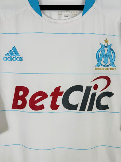 Détail de l'écusson OM brodé avec étoile dorée de 1993 et devise Droit au But, maillot 2010-2011