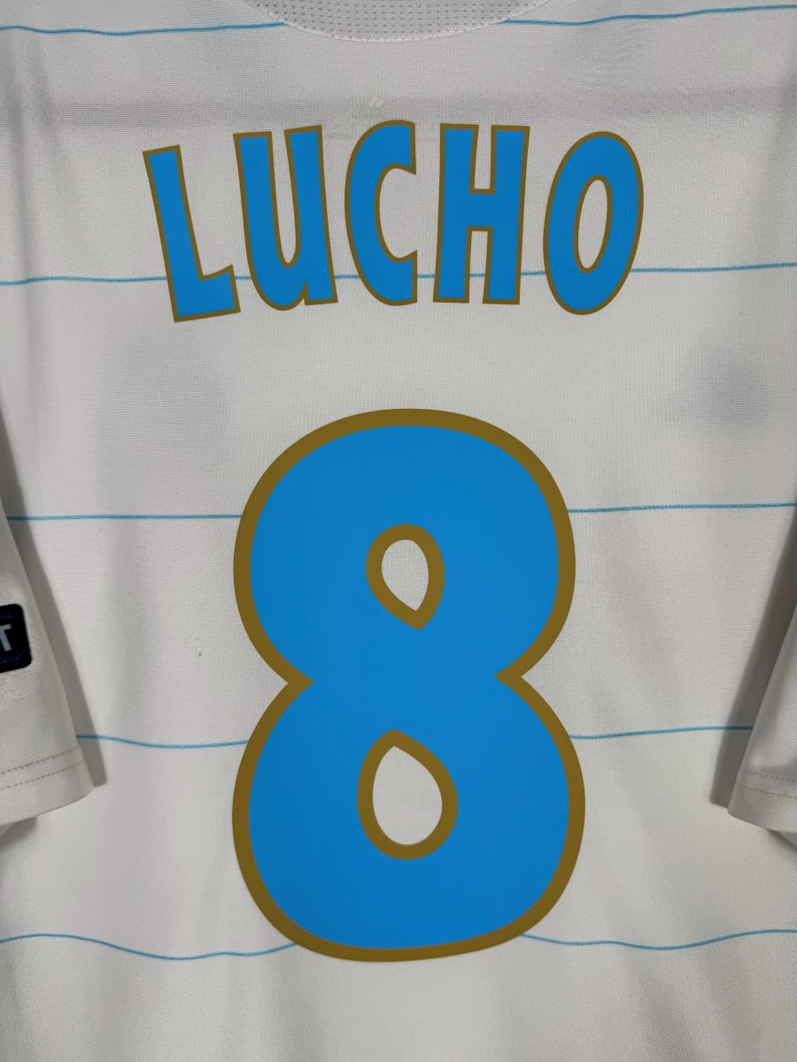 Gros plan du flocage Lucho N°8 bleu ciel cerclé d'or sur le maillot OM domicile 2010-2011