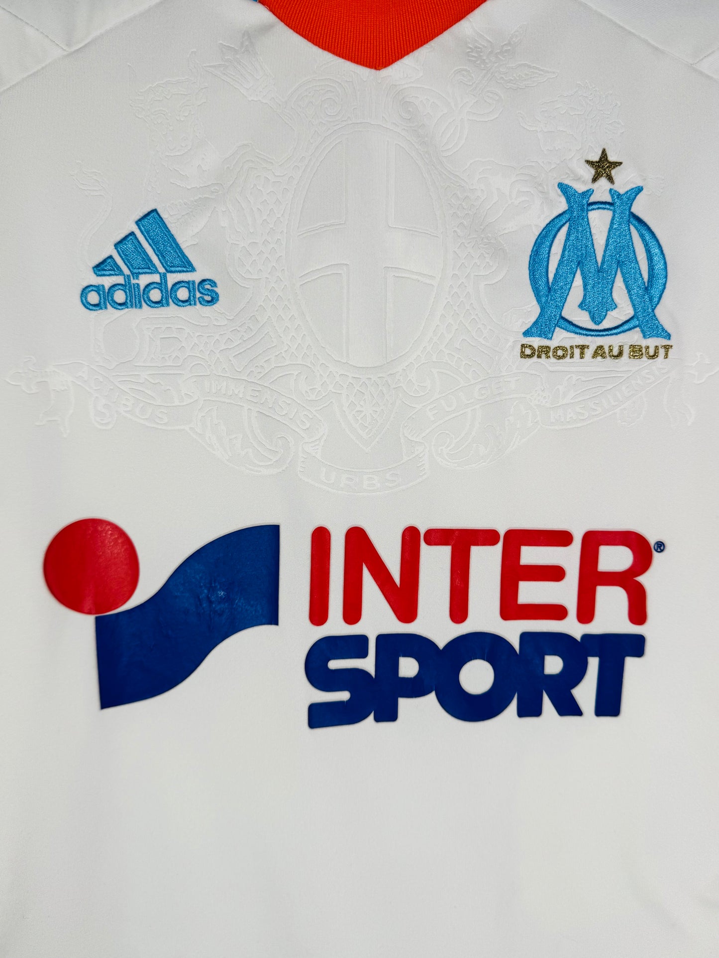 Détail de l'écusson de l'Olympique de Marseille et du logo Adidas