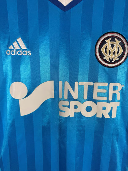 Detail de l ecusson brode de l OM et du sponsor Intersport