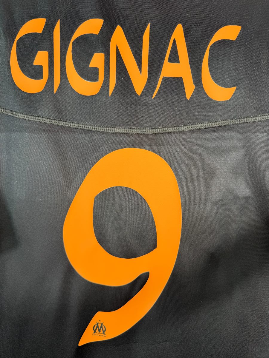Détail du flocage orange Gignac 9 avec mini-logo OM, maillot third 2012-2013