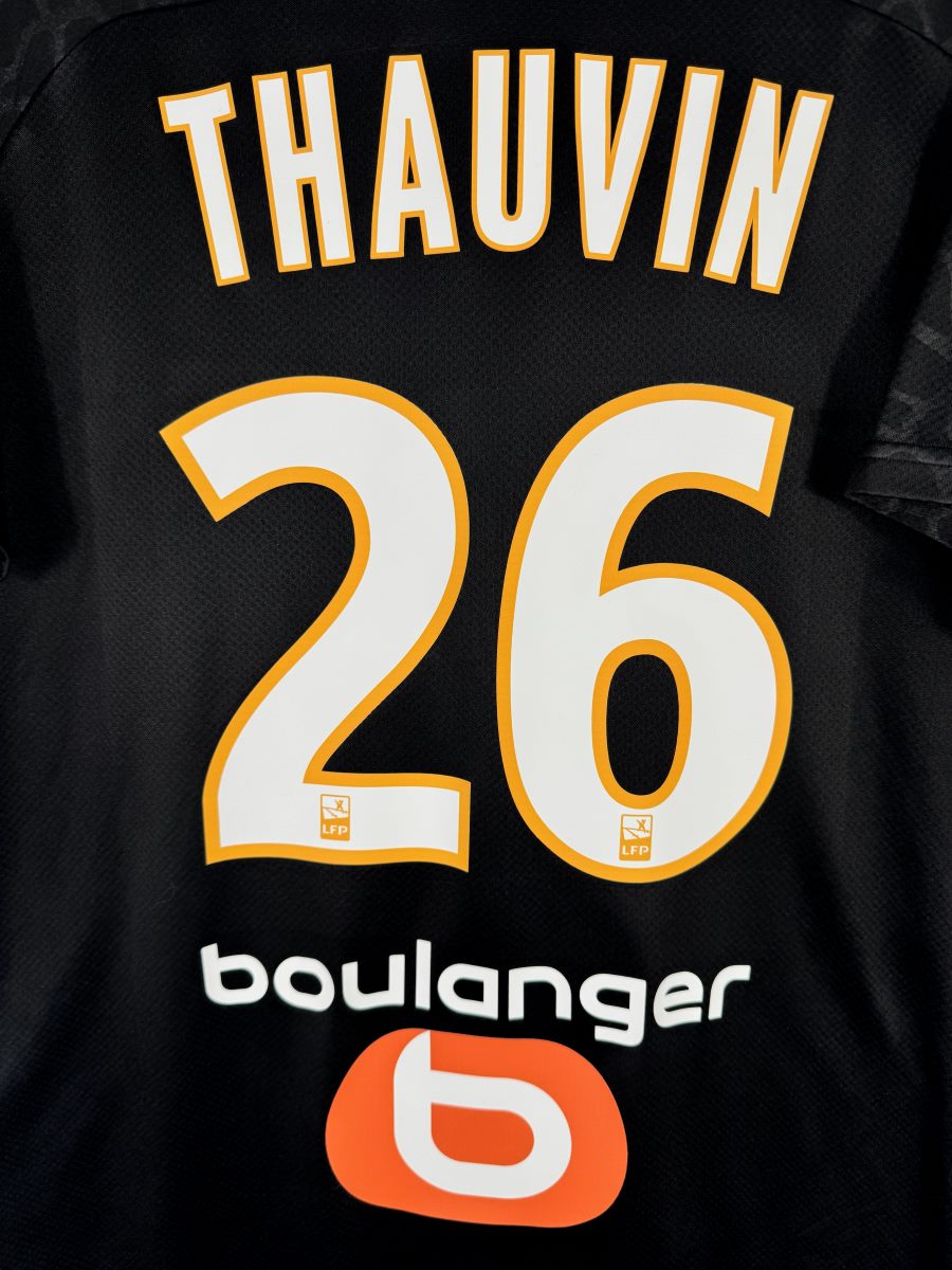 Détail flocage Thauvin 26 blanc et orange avec logos LFP, maillot OM third 2019-2020