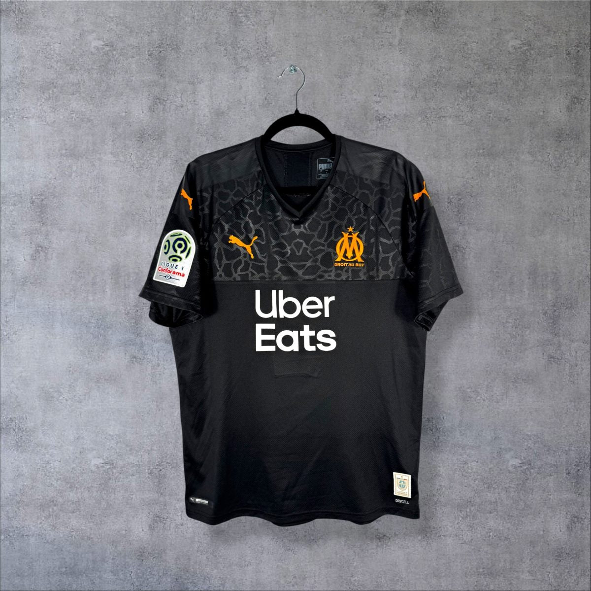 Face du maillot OM 2019-2020 third Puma noir, sponsor Uber Eats et patch Ligue 1 Conforama sur la manche