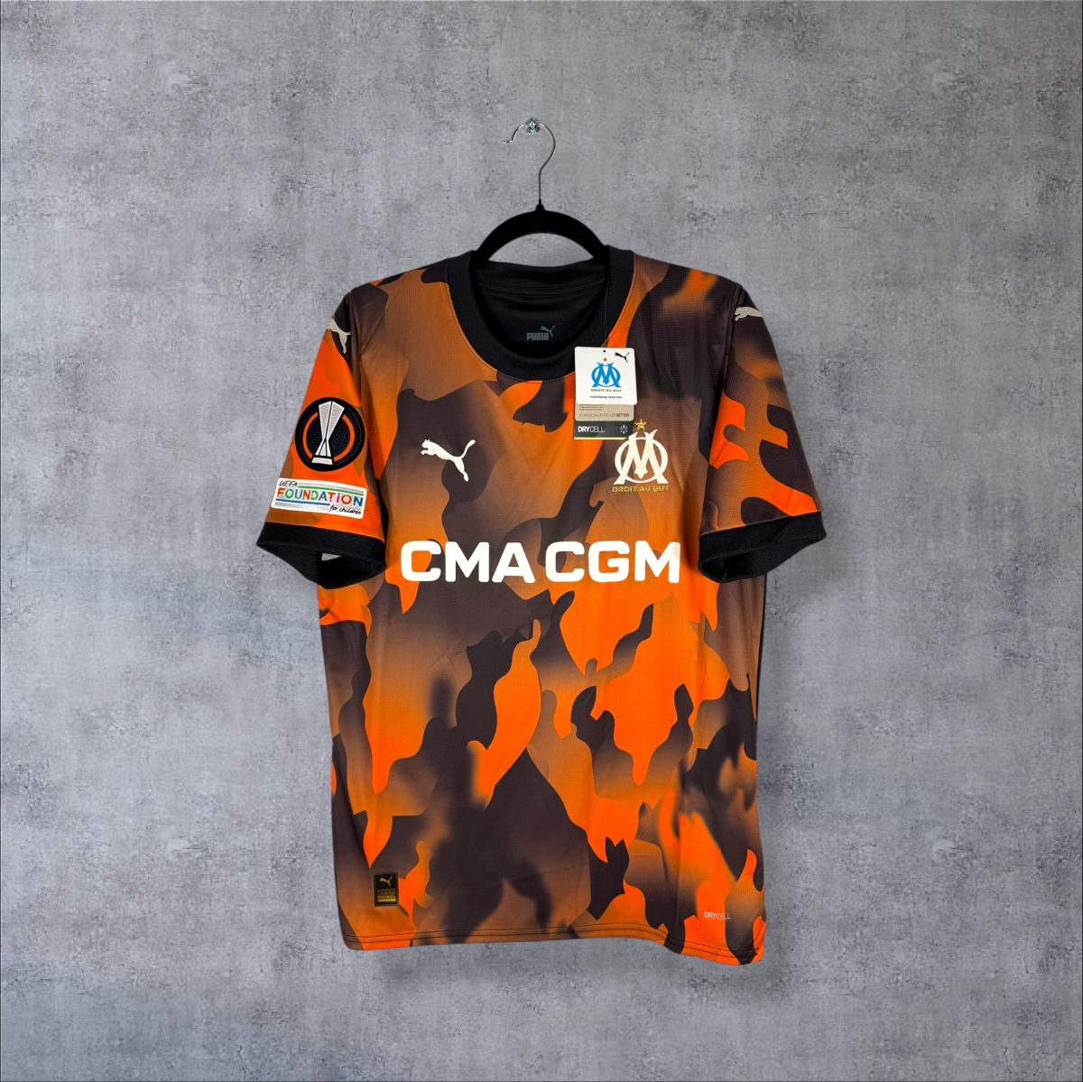 Face du maillot OM 2023-2024 third Puma camouflage orange et noir, sponsor CMA CGM, étiquettes d'origine