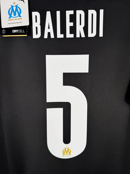 Gros plan du flocage officiel Balerdi N°5 avec écusson OM doré intégré, maillot third 2023-2024