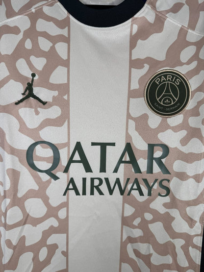 Détail de l'écusson PSG doré et du logo Jumpman sur le maillot fourth 2023-2024