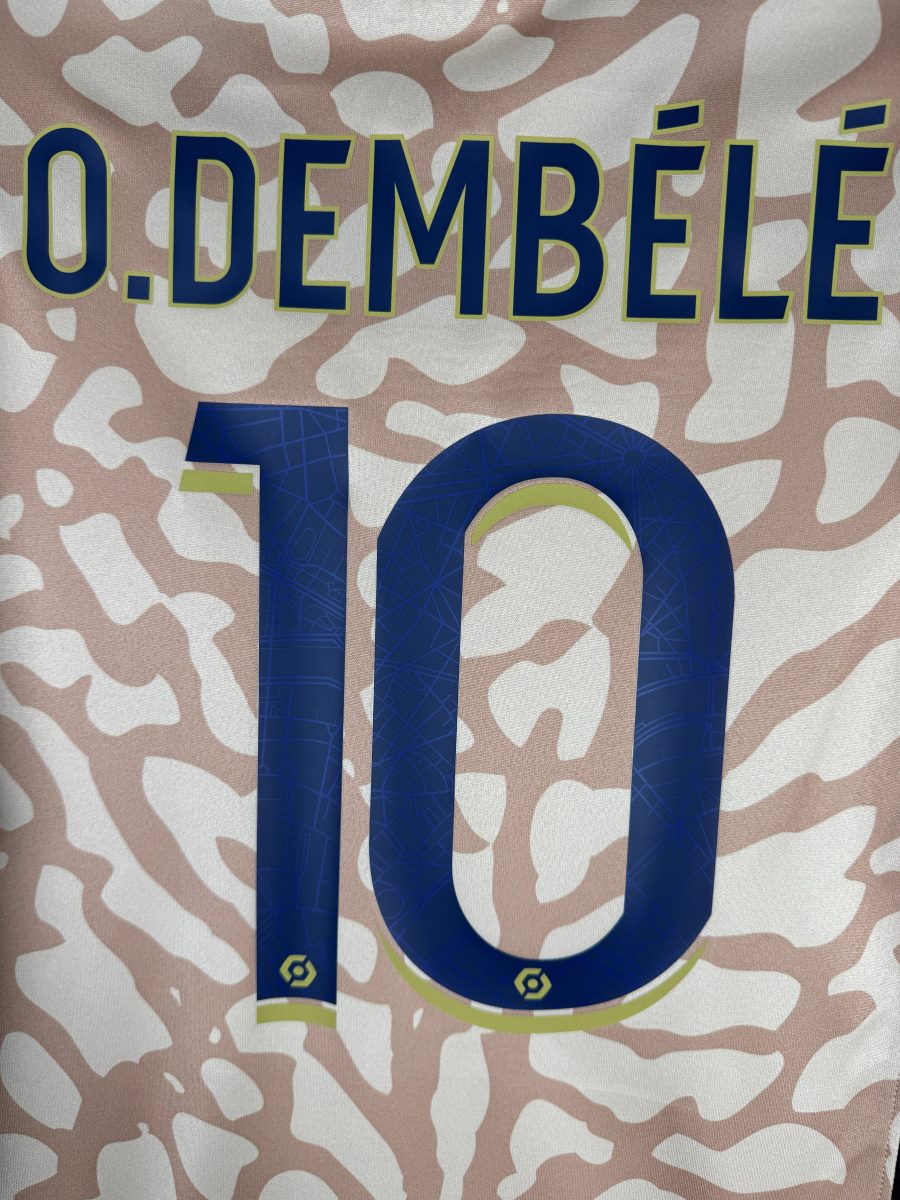 Gros plan du flocage Dembélé 10 avec motif plan de Paris et logo Ligue 1, maillot PSG fourth 2023-2024