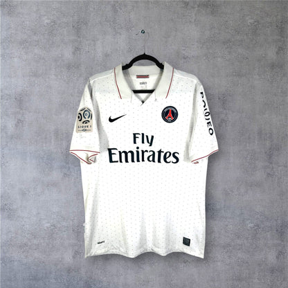 Vue de face du maillot PSG Extérieur 2009/10 blanc avec motifs à pois rouges et bleus et sponsor Fly Emirates.