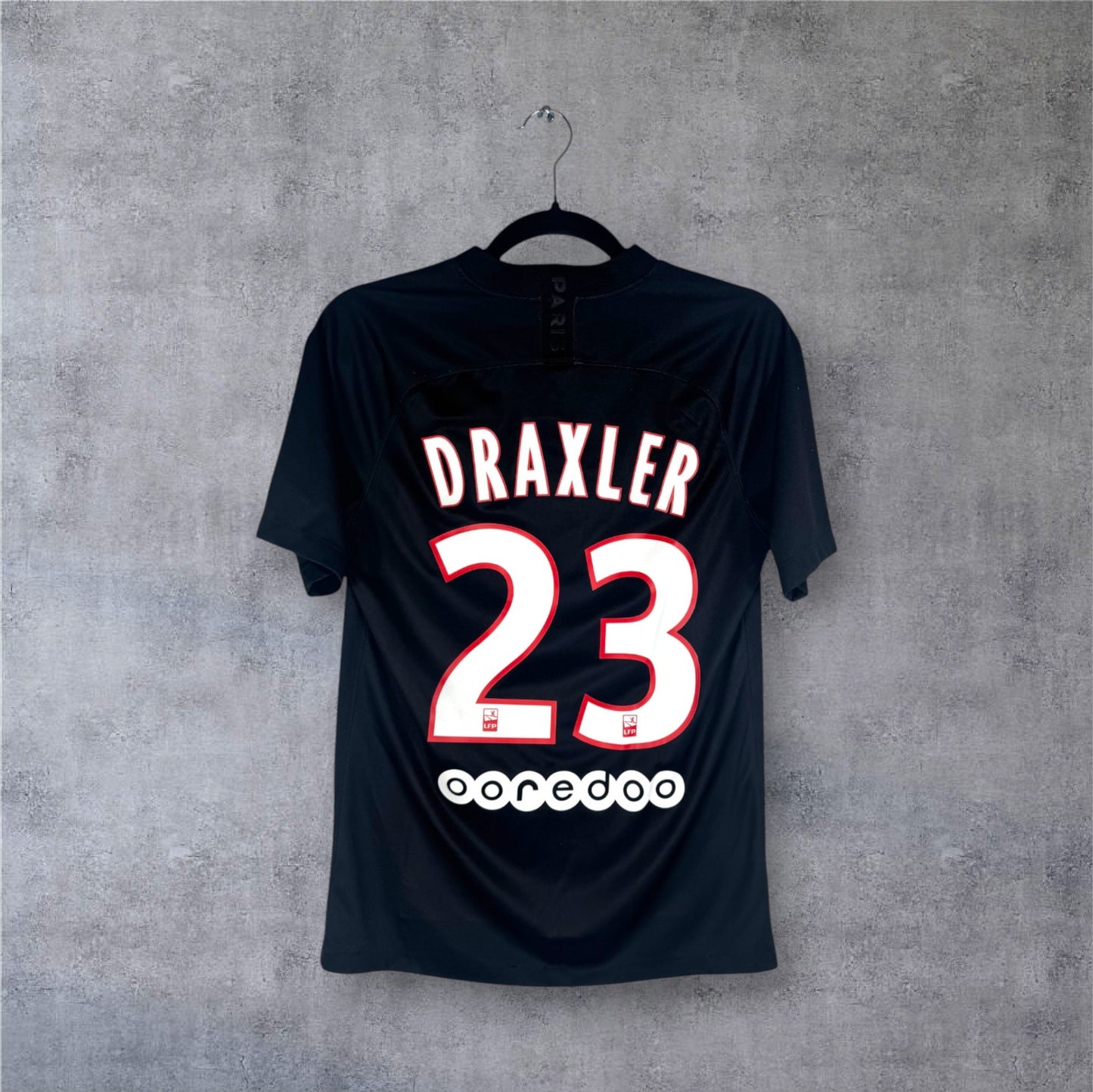 Flocage officiel blanc DRAXLER numéro 23 et sponsor Ooredoo au dos du maillot PSG noir.