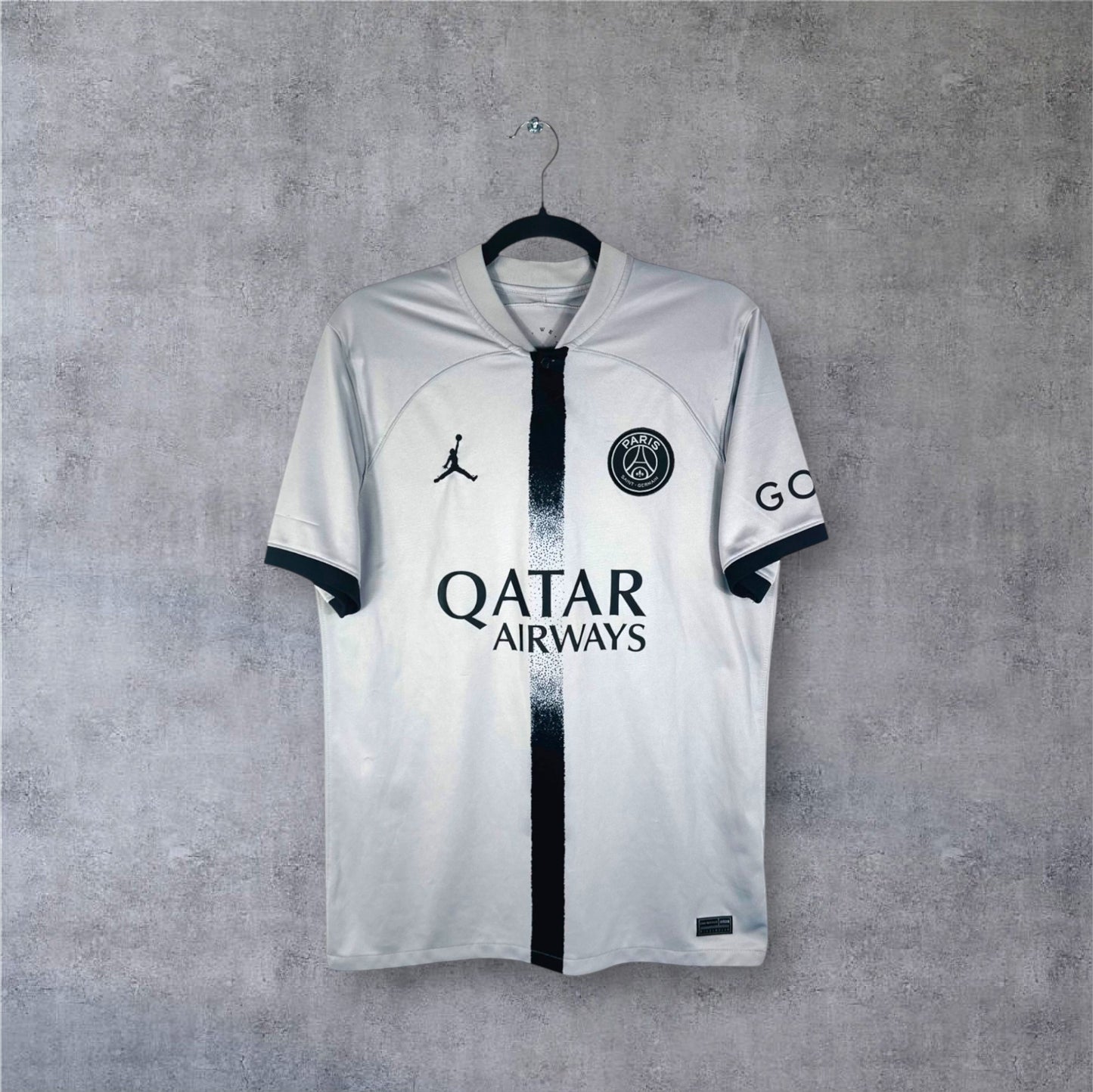 Vue de face du maillot gris PSG Jordan 2022/23 avec bande centrale noire fondue.