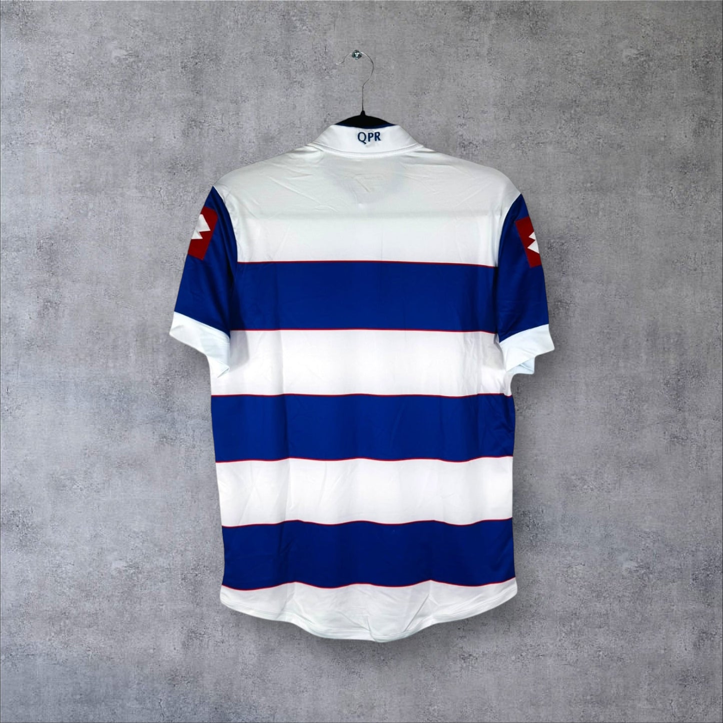 Vue arrière du maillot QPR 2013-2014 avec larges bandes horizontales bleues et blanches.