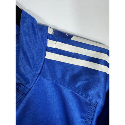 Gros plan sur la légère usure des bandes Adidas sur les épaules du maillot du Real Madrid