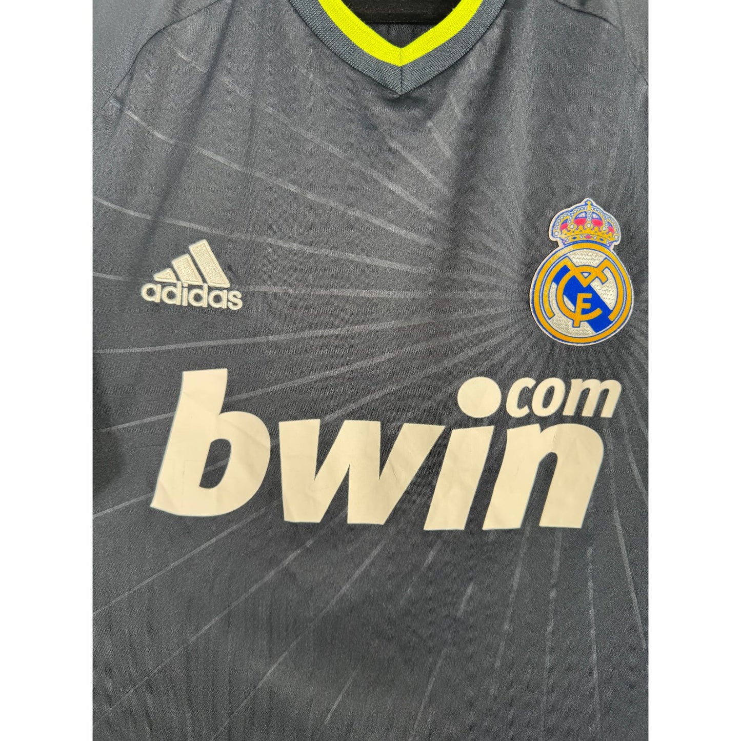 Détail de l'écusson du Real Madrid et du logo Adidas vert fluo