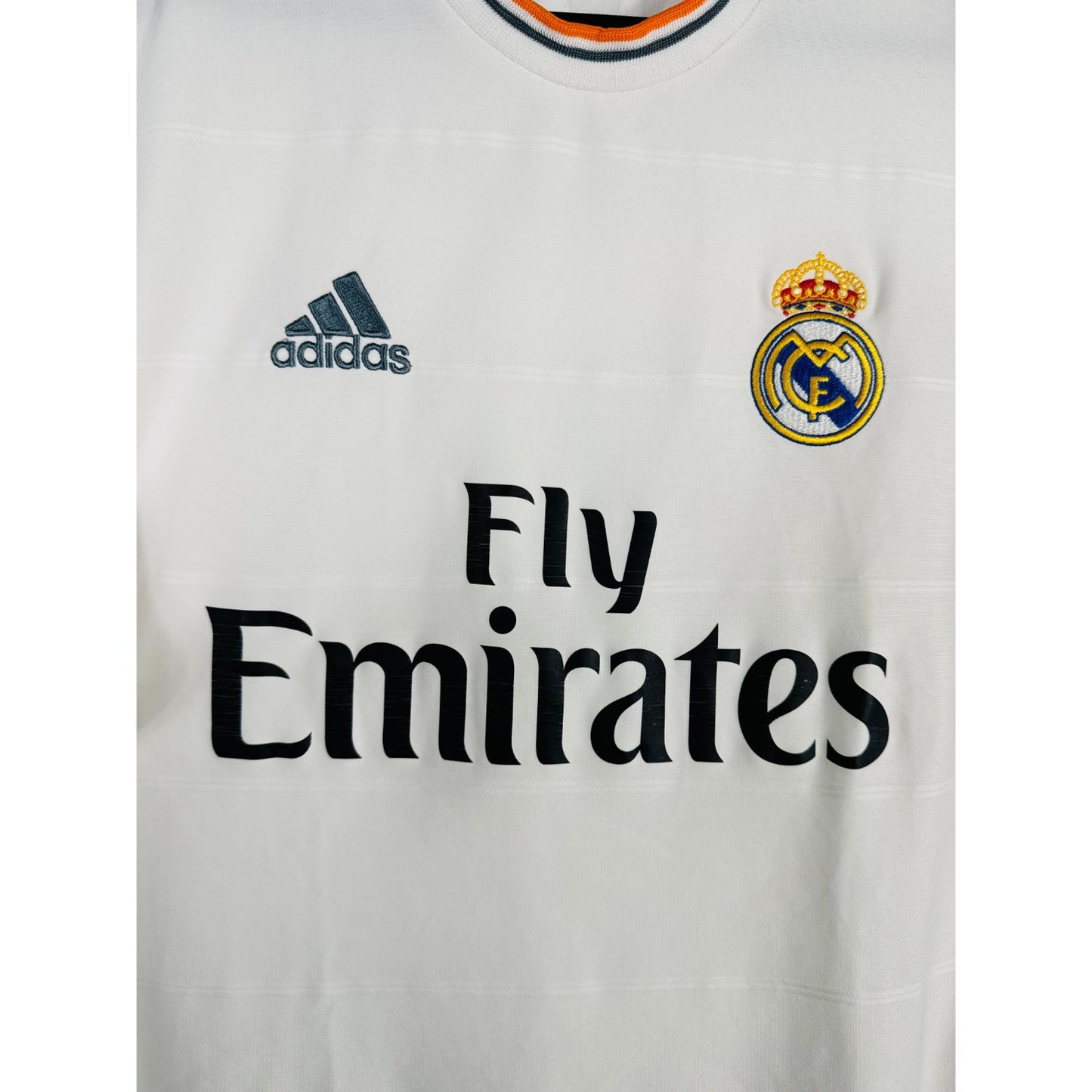 Détail de l'écusson du Real Madrid et du logo Adidas orange