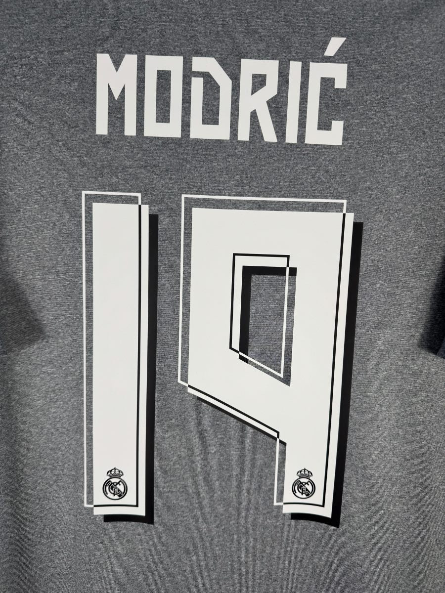 Gros plan du flocage MODRIĆ N°19 avec écussons du Real intégrés aux chiffres