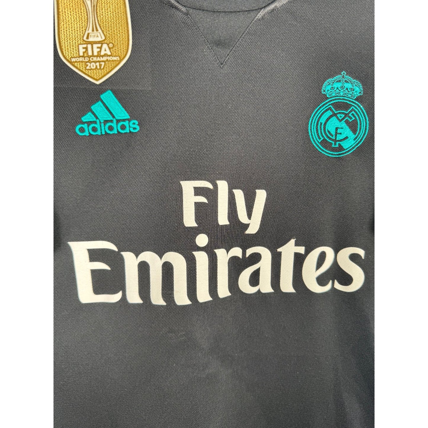 Détail de l'écusson du Real Madrid et du logo Adidas turquoise