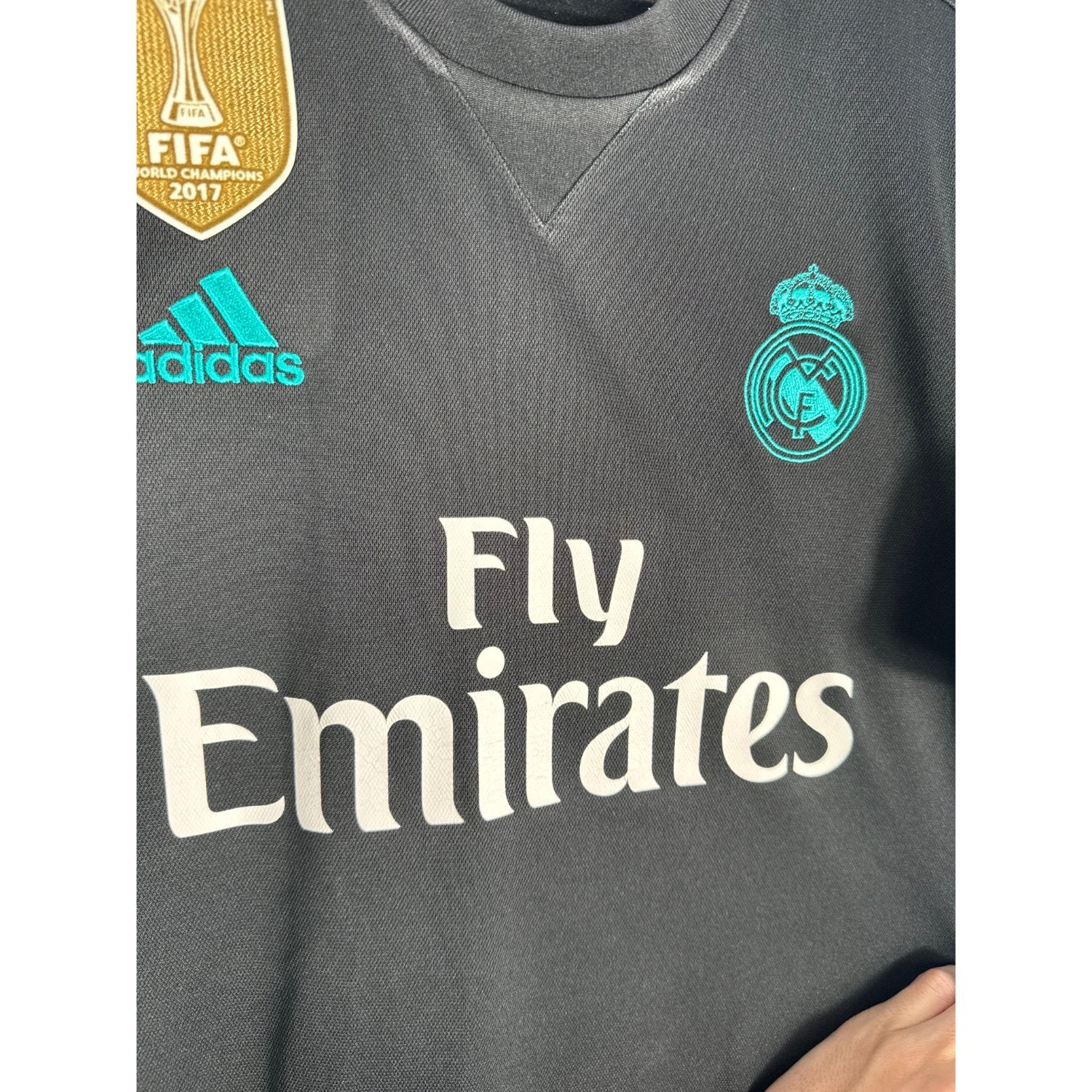 Détail de l'écusson du Real Madrid et du logo Adidas turquoise