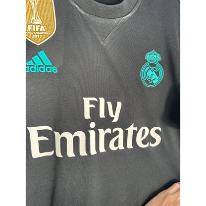 Détail de l'écusson du Real Madrid et du logo Adidas turquoise