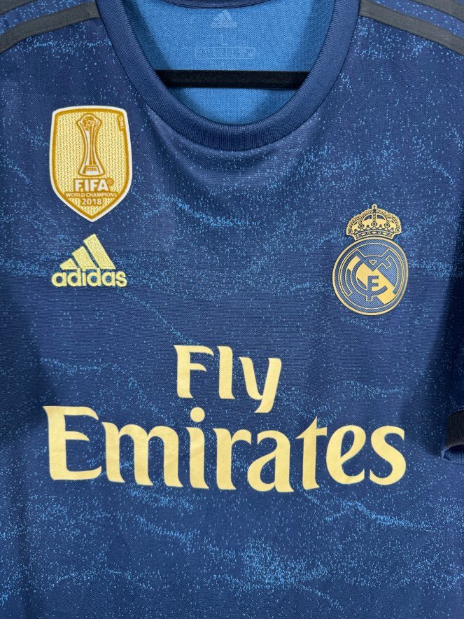 Détail de l'écusson du Real Madrid et du logo Adidas doré