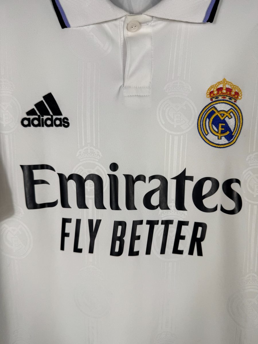 Détail de l'écusson Real Madrid brodé et du motif jacquard à écussons du maillot domicile 2022-2023